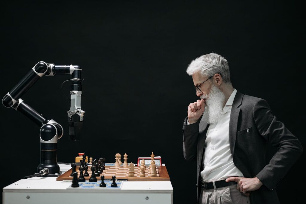 pexels photo 8438918 An elderly scientist contemplates a chess move against a robotic arm on a chessboard.